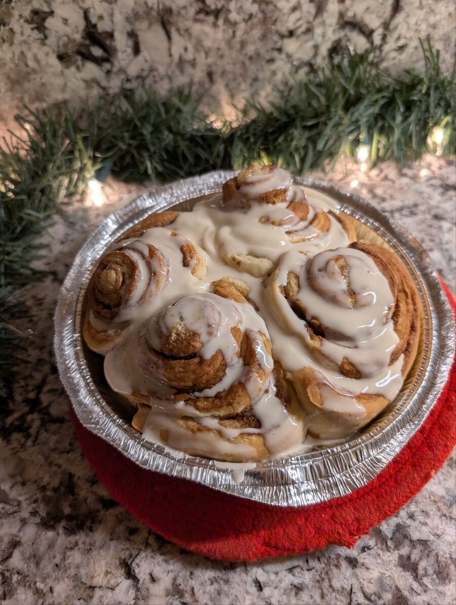 Frosted cinnamon rolls in a round tin
